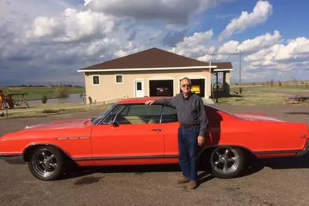 Man taking photo whit his red car